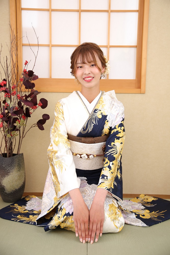 成人式の前撮りで白と紺の色分けの振袖をきて正座をしている女性